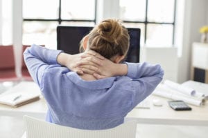 Business woman at desk holding neck and upper back from pain and fatigue