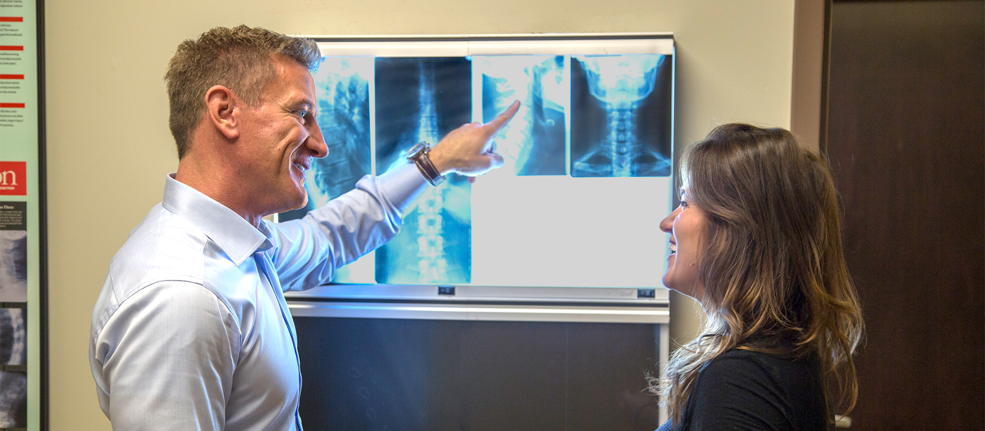 Dr Crist showing a female patient her chiropractic back x-rays