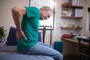 man grabbing his lower back from pain likely caused by piriformis syndrome