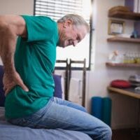 man grabbing his lower back from pain likely caused by piriformis syndrome